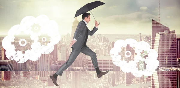 Uomo d'affari saltando e tenendo ombrello — Foto Stock