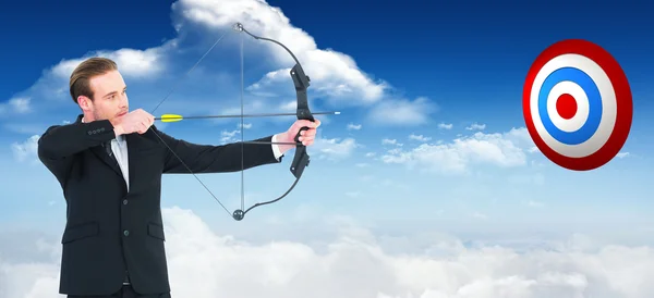 Businessman shooting bow and arrow — Stock Photo, Image