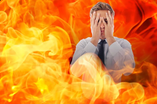 Empresário com dor de cabeça contra o fogo — Fotografia de Stock