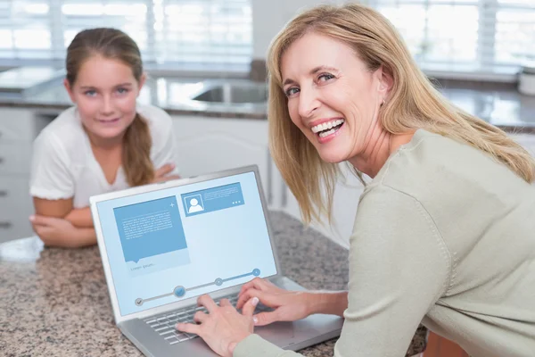 Mãe feliz usando laptop com filha — Fotografia de Stock