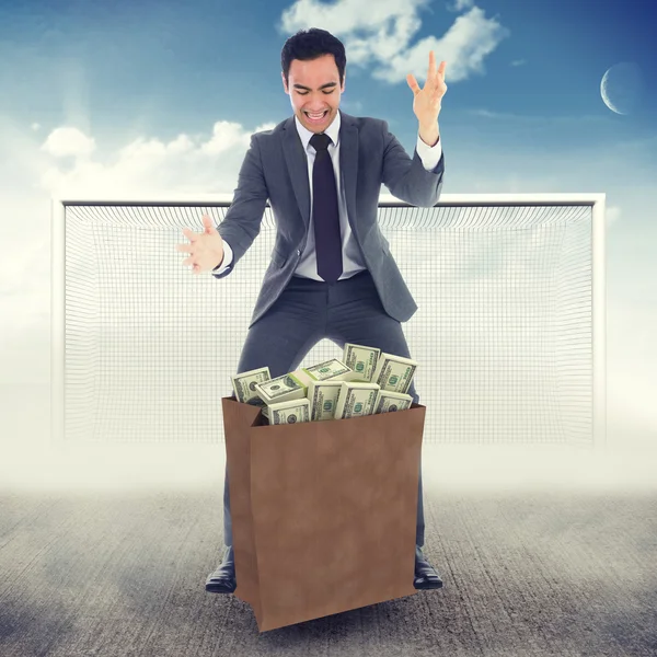 Excited businessman catching dollars bag — Stock Photo, Image