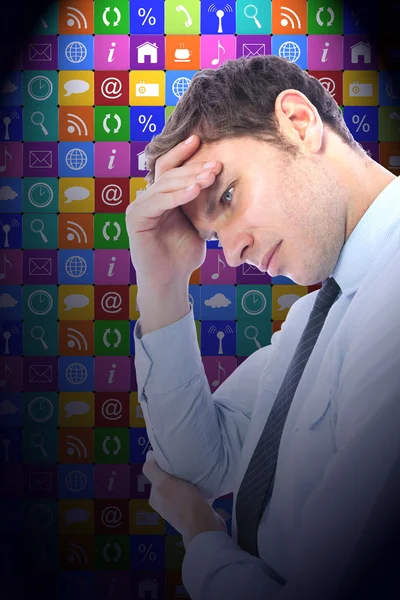 Businessman with a headache against app wall — Stock Photo, Image