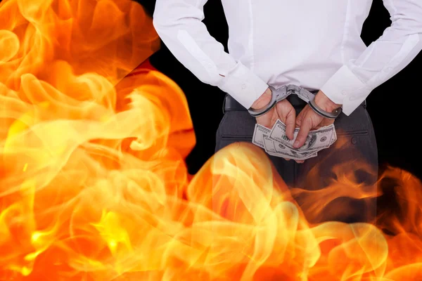 Businessman in handcuffs holding bribe — Stock Photo, Image