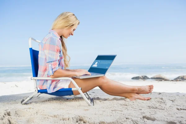 Vrouw zittend op het strand en met behulp van laptop — Stockfoto