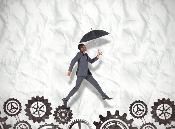 Businessman walking and holding umbrella — Stock Photo, Image