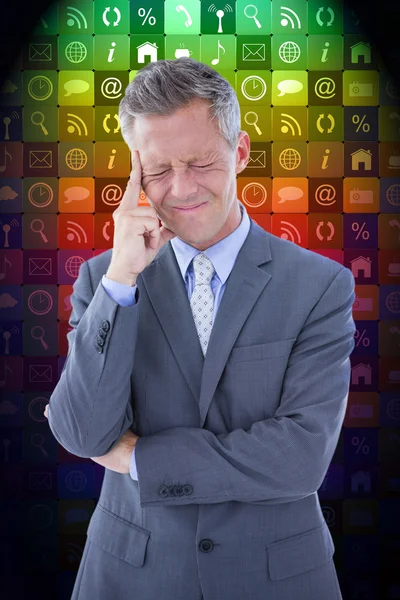 Businessman with headache against app wall — Stock Photo, Image