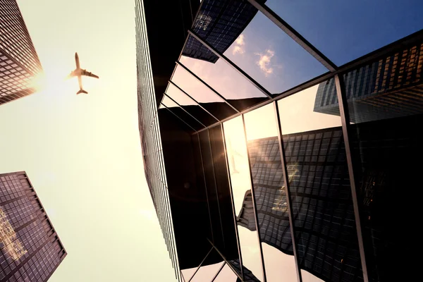 Flying airplane and skyscrapers — Stock Photo, Image