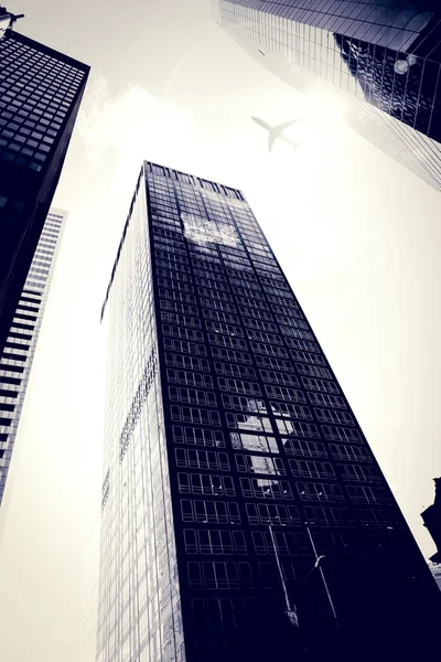 Flying airplane and skyscrapers — Stock Photo, Image