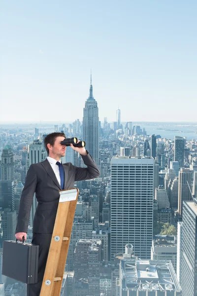 Businessman looking on ladder — Stock Photo, Image