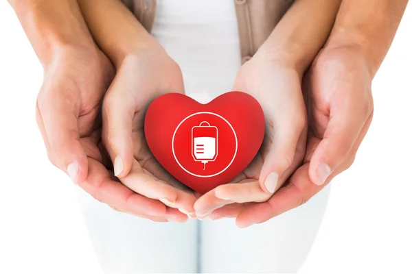 Couple holding miniature heart in hands — Stock Photo, Image