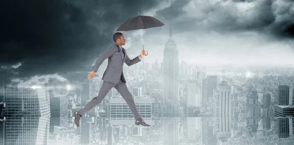 Uomo d'affari che cammina e tiene in mano l'ombrello — Foto Stock