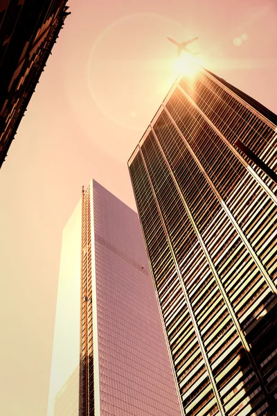 Airplane flying over buildings — Stock Photo, Image