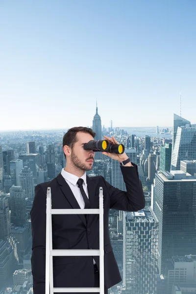 Businessman looking on ladder — Stock Photo, Image