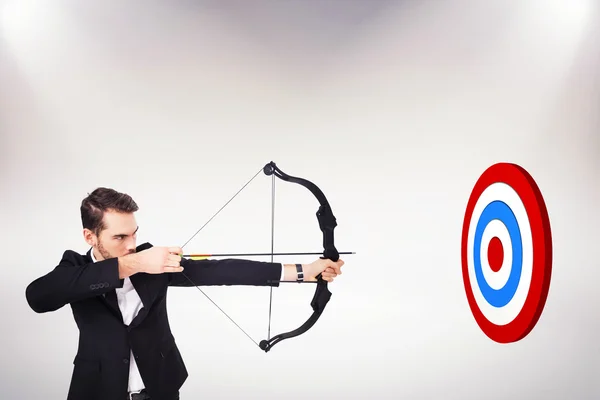 Businessman shooting bow and arrow — Stock Photo, Image