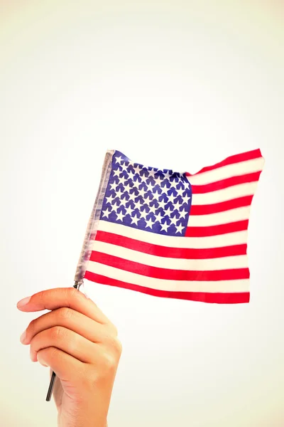 Zusammengesetztes Bild der Hand, die die amerikanische Flagge schwenkt — Stockfoto