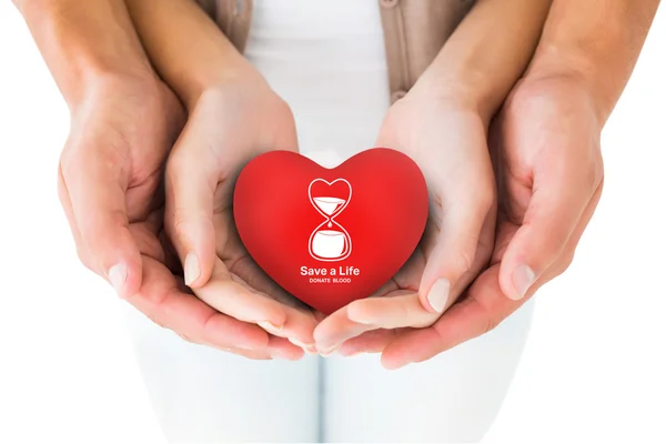 Couple holding miniature heart in hands — Stock Photo, Image