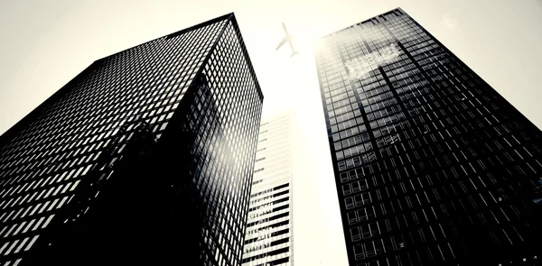 Airplane flying over buildings — Stock Photo, Image