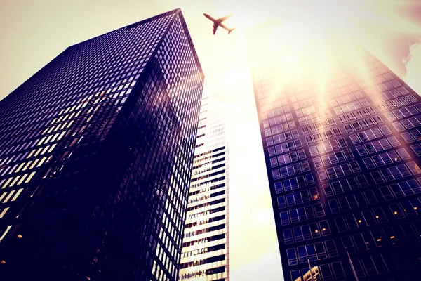 Flying airplane and skyscrapers — Stock Photo, Image