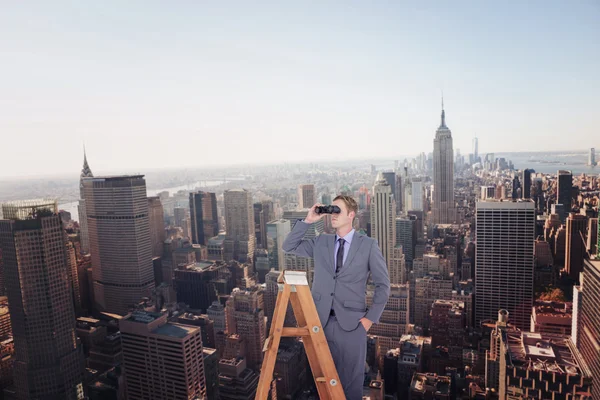 Businessman looking on ladder — Stock Photo, Image