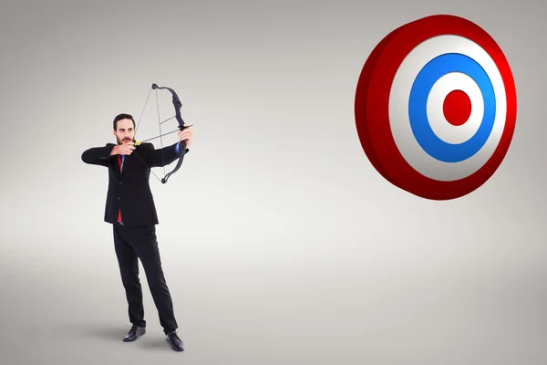Focused businessman shooting bow and arrow — Stock Photo, Image
