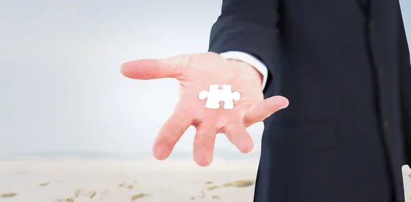 Businessman with jigsaw piece in table — Stock Photo, Image