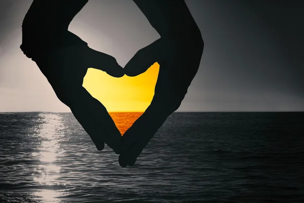 Hands forming heart against sunset — Stock Photo, Image