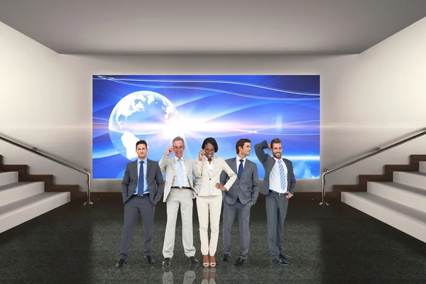 Business team against grey room — Stock Photo, Image