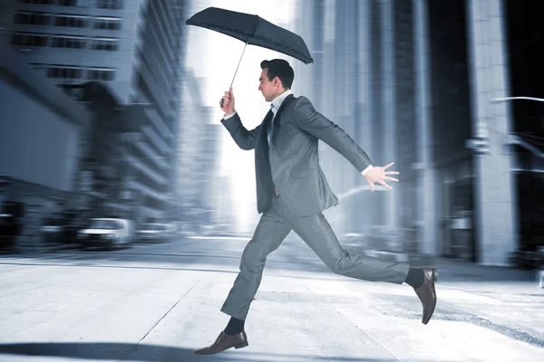 Бизнесмен прыгает с зонтиком в руках — стоковое фото