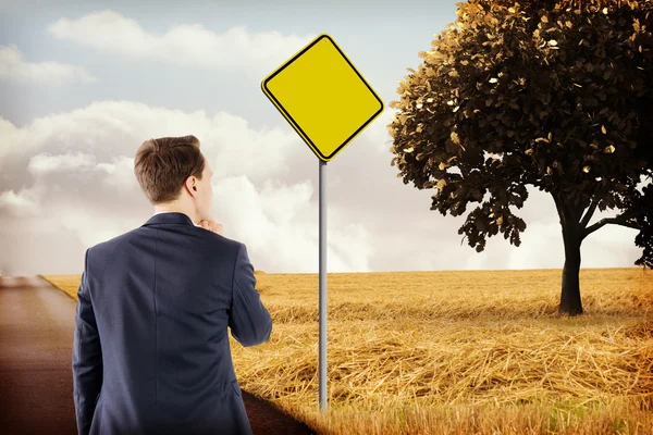 Empresario pensando en contra de signo amarillo — Foto de Stock