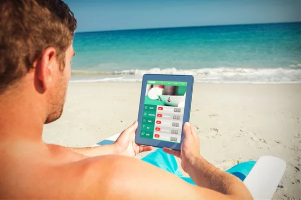 Man using digital tablet on deck chair — Stock Photo, Image