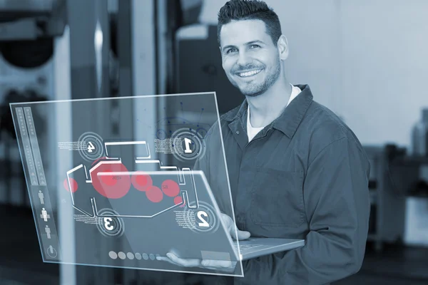 Smiling mechanic using his laptop — Stock Photo, Image