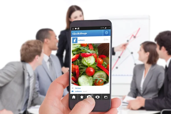 Female hand holding a smartphone — Stock Photo, Image