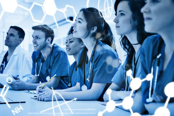 Students listening and sitting at desk — Stock Photo, Image