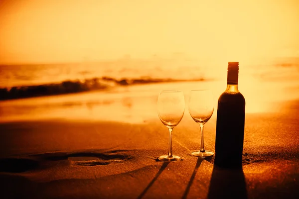 Butelka wina w okularach na plaży — Zdjęcie stockowe