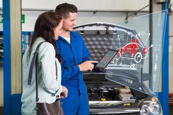 Mechanik ukazující zákazník problém s autem — Stock fotografie