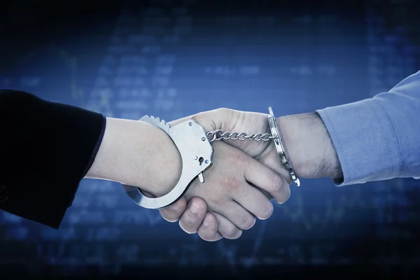 Business people in handcuffs shaking hands — Stock Photo, Image