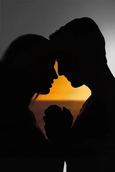 Sunset against silhouette of couple faces — Stock Photo, Image