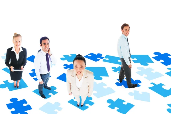 Team di lavoro contro pezzi di puzzle blu — Foto Stock