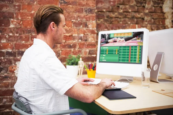 Arbetstagaren att skriva på laptop vid sitt skrivbord — Stockfoto