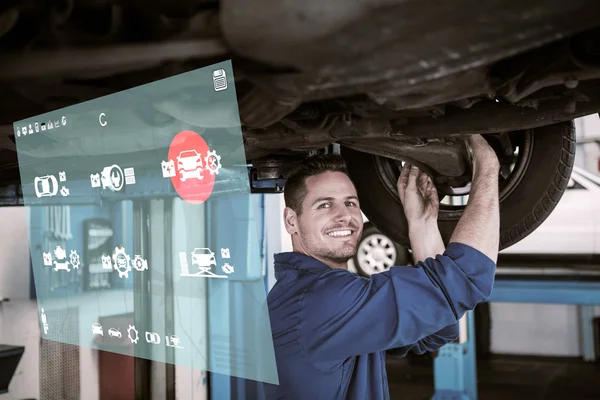Mecánico sonriente ajustando la rueda del neumático — Foto de Stock