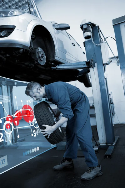 Mechanic adjusting the tire wheel — Stock Photo, Image