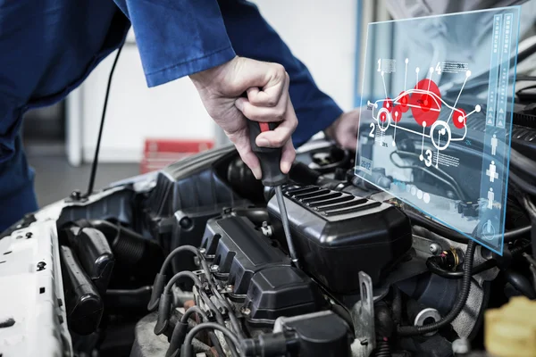 Mechanic using screwdriver on engine — Stock Photo, Image