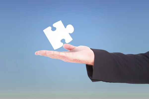 Businessman holding jigsaw piece — Stock Photo, Image