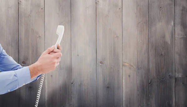 Composite image of businessman holding phone — Stock Photo, Image