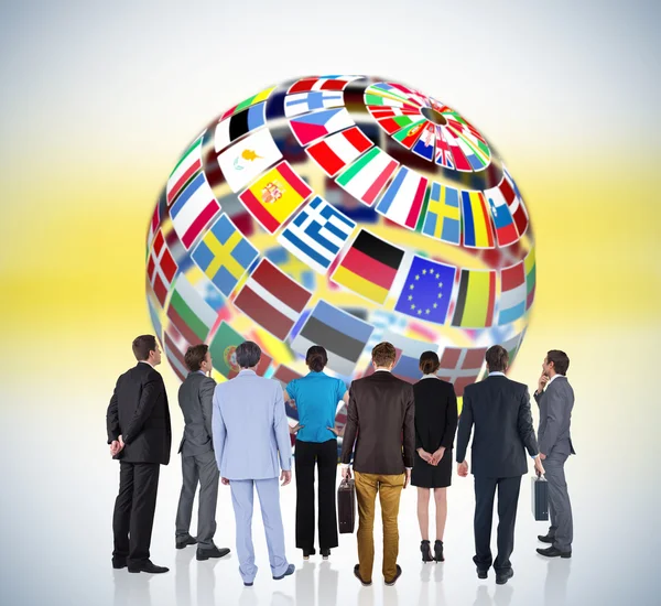 Business team against earth made of flags — Stock Photo, Image