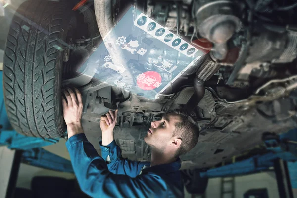 Mechanic onder auto in de garage — Stockfoto