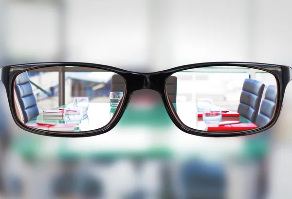 Glasses against empty meeting room — Stock Photo, Image