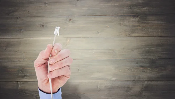 Businessman holding a cable — Stock Photo, Image