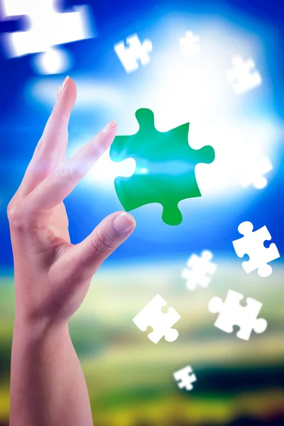 Hand showing jigsaw piece — Stock Photo, Image