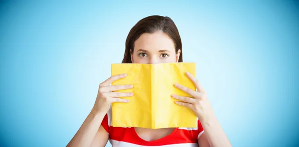 Student covering face with book — Stock Photo, Image